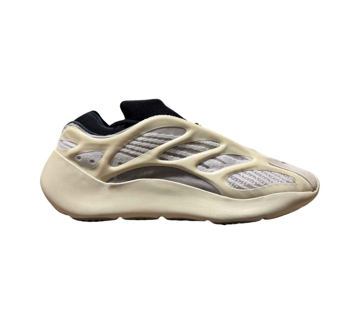 Genesis Boutique used Yeezy 700 Azael sneakers in off-white and black with visible toe stains, side profile view.