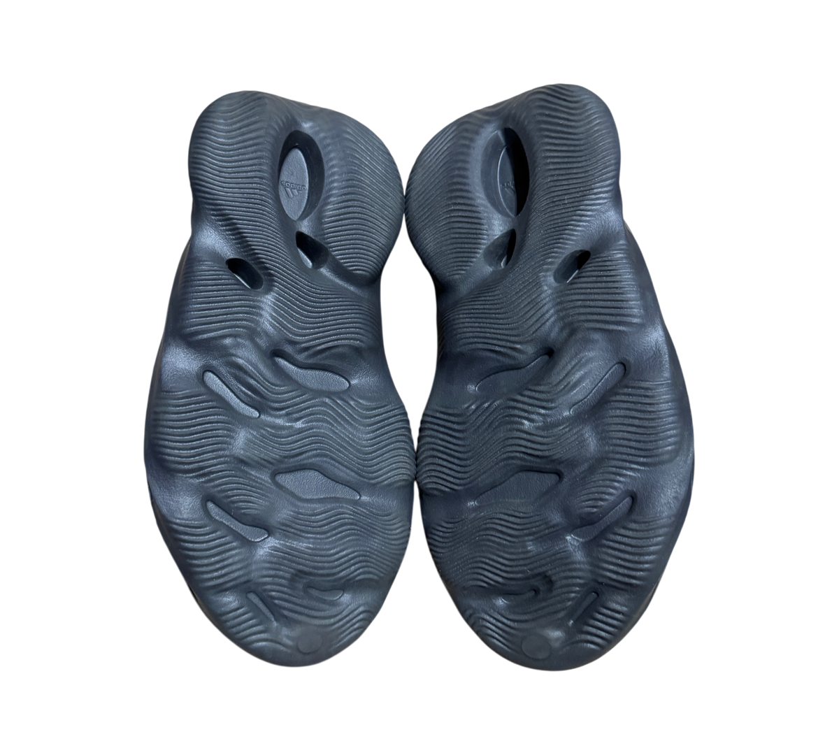 Genesis Boutique Yeezy Foam Runner Onyx shoes showing the black textured outsoles with wave patterns