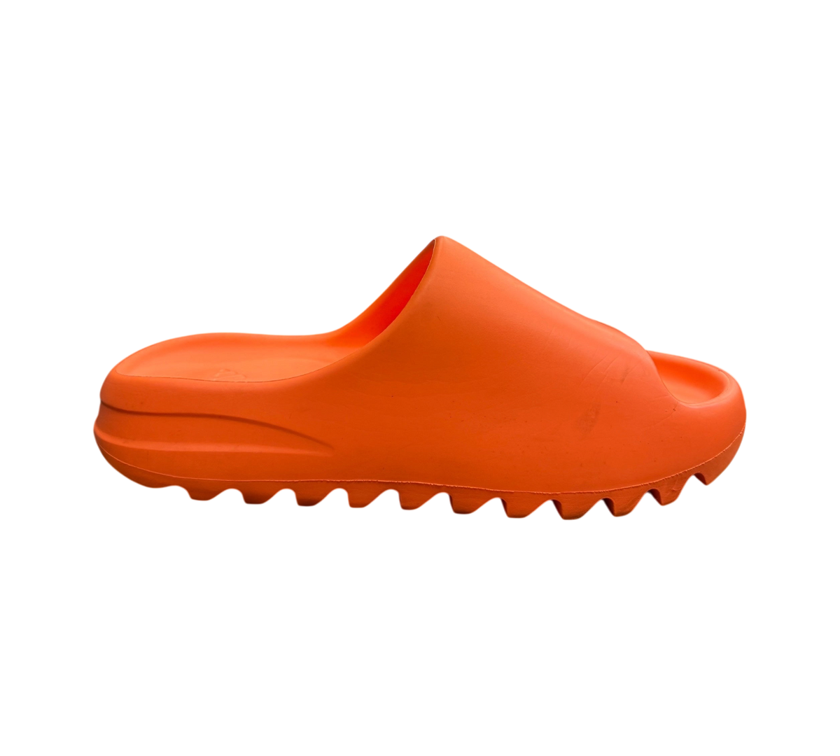 Genesis Boutique Yeezy Slide Enflame Orange in a vibrant bright orange foam material with a serrated outsole