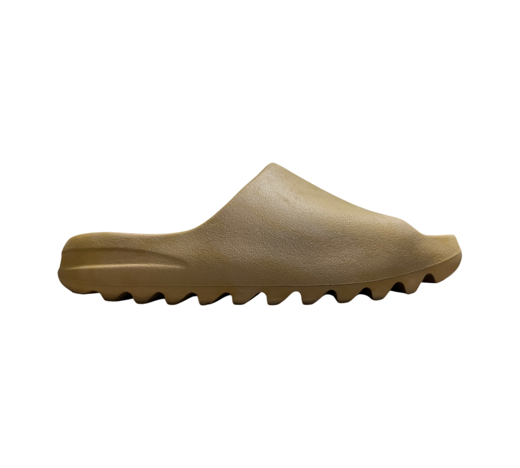 Genesis Boutique Yeezy Slide Ochre in a tan foam material with a signature serrated outsole, side profile view.